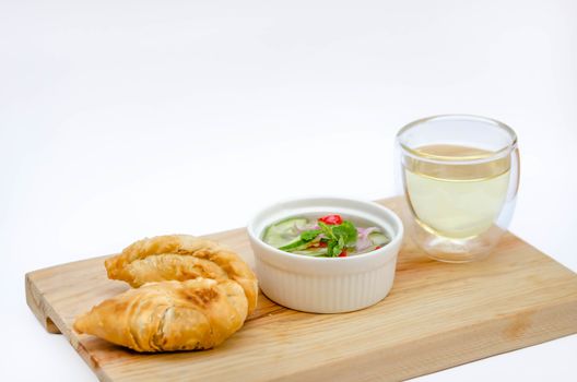 Curry puff pastry with sweet sauce  on wooden plate