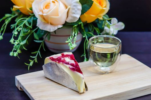 blueberries cheese cake on wooden plate with hot tea
