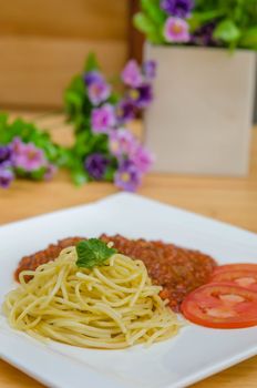 Spaghetti Bolognese meal with basil leaves and tomatoes