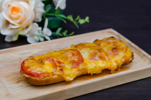 homemade French bread roll, topped with fresh tomatoes, melted cheddar, Mozzarella and Parmesan .
