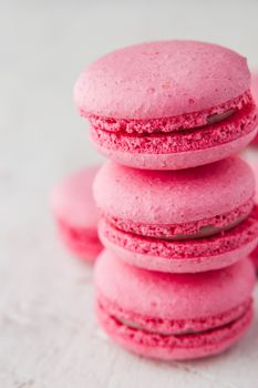 Pink macaroon on a white table vertical