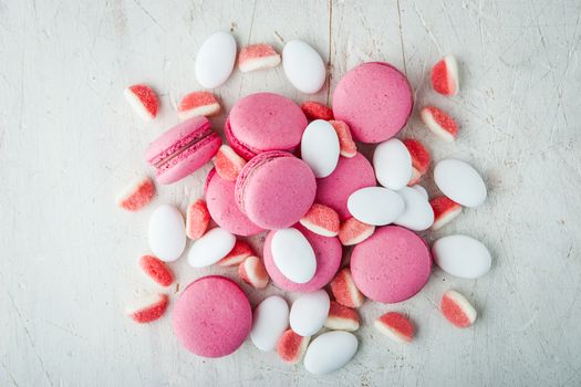 Pink macaroon and marmalade on a white wooden table horizontal