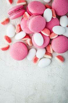 Pink macaroon and marmalade on a white wooden table vertical