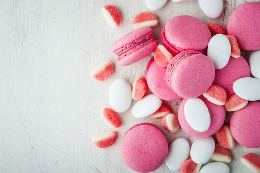 Pink macaroon and marmalade on a white wooden table horizontal
