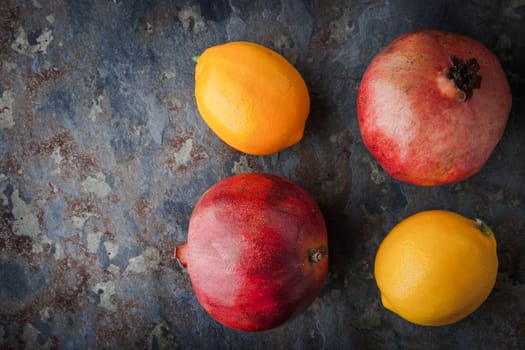 Lemons, pomegranates on the stone table horizontal