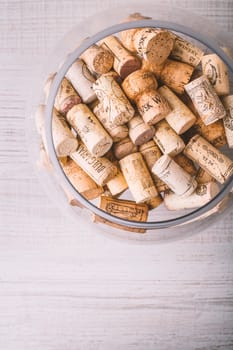 Glass vase with corks on the wooden table vertical