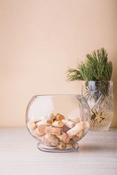Vase with corks and coniferous branch on the table vertical