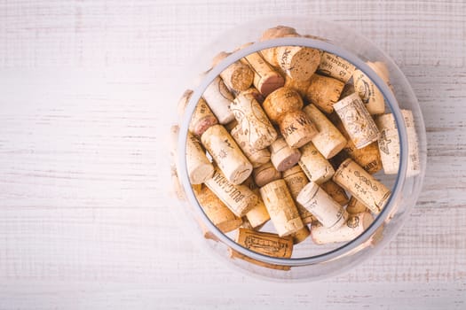 Glass vase with corks on the wooden table horizontal