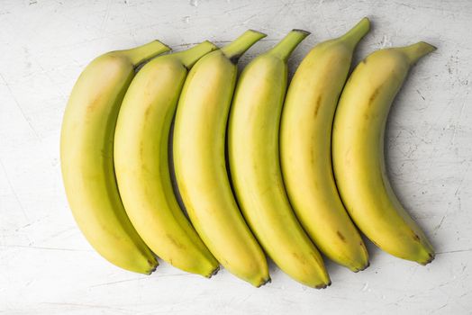 Yellow bananas are laid out in a rectangle horizontal