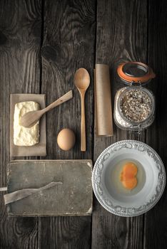 Recipe book, plate and ingredients for cookies on a wooden table vertical