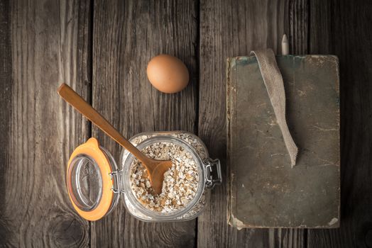 Book of recipes and ingredients for cookies on a wooden table horizontal super still life