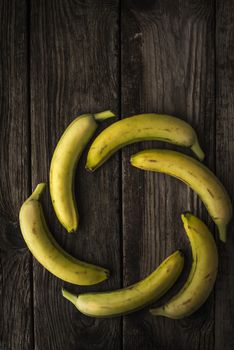 Yellow bananas on old wooden boards vertical
