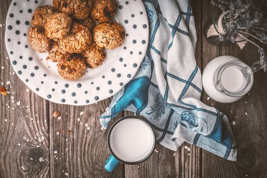 Pitcher, lavender, oatmeal cookies and a cup of milk on old boards horizontal