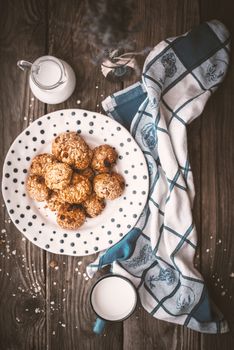 Pitcher, lavender, oatmeal cookies and a cup of milk on old boards vertical