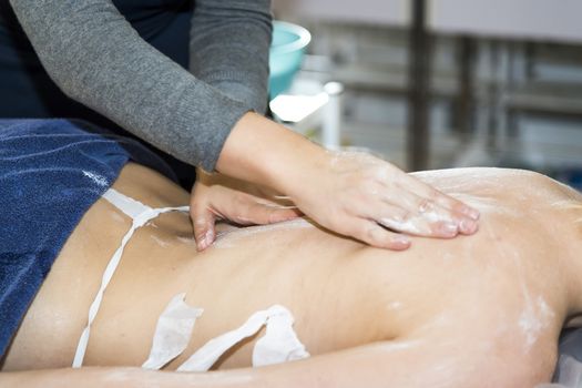 Massaging of young woman in SPA