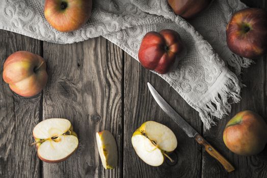 Red apples and apple halves on a wooden table horizontal