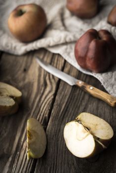 Red apples and apple halves on a wooden table vertical