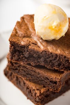 Brownie with ice cream on a white ceramic plate vertical  