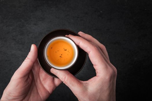 A woman holding a cup of tea horizontal