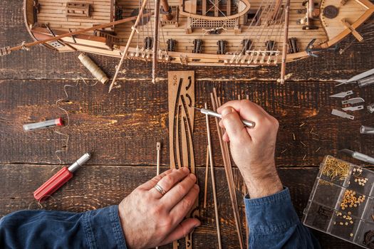 Man collects the vehicle model on the wooden table horizontal