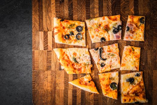 Slices of pizza on a wooden board horizontal