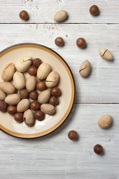 Pecan and macadamia nuts on the white wooden table vertical
