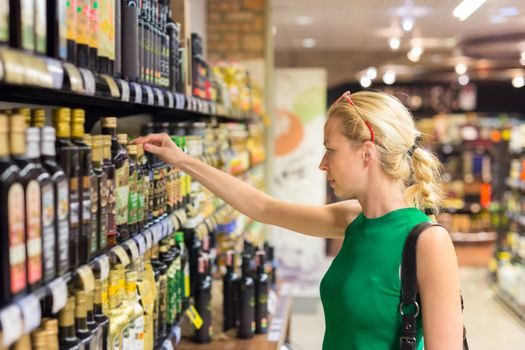 Beautiful caucasian woman shopping groceries at supermarket.