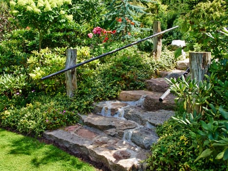 Natural stone stairs landscaping in beautiful lush green blooming home garden