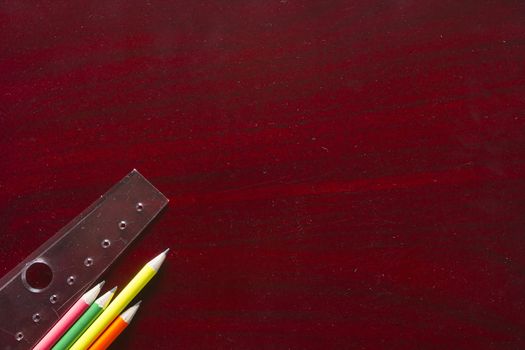 Pencils and ruler on red wooden table