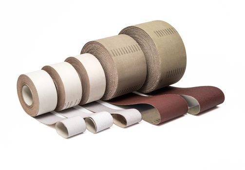Sandpaper in rolls for industrial use in different sizes and thickness on white background