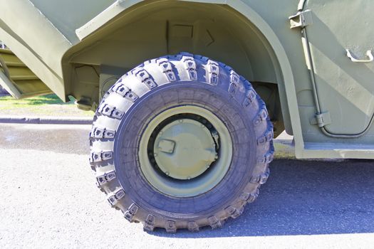 Wheel of military machine at the exhibition under open sky