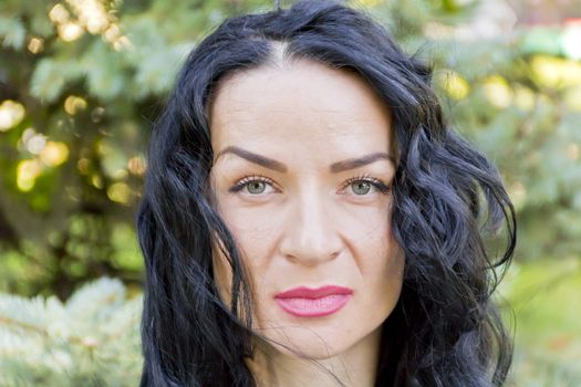 European woman with black hair on green