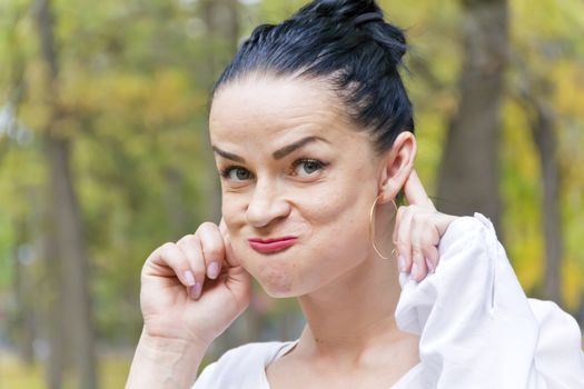 Funny woman with black hair in autumn park