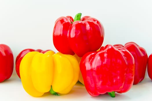 Photo of fresh red and yellow raw pepper on white background