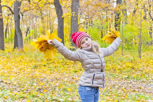 Playing girl with two bouquets from sheets in park
