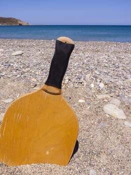 Racket in the sand of the beach in a sunny day. Summertime. Crete, Greece.