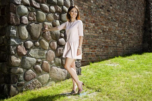 Attractive woman against very nice brick wall.