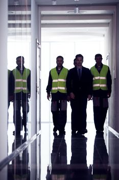 Team of workers and manager walking at the corridor of factory