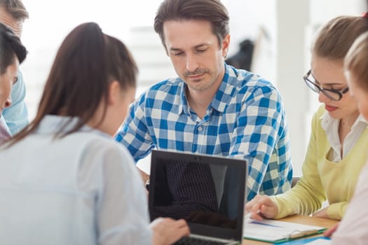 Diverse people working with financial reports and laptop