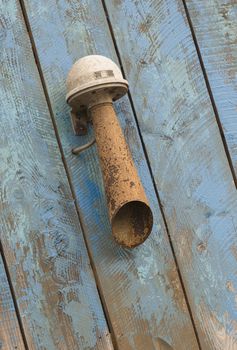 Old rusted sound horn on a blue weathered wooden background
