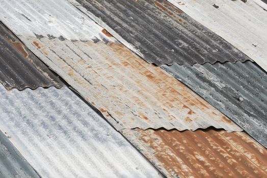 Old weathered corrugated metal as colorful roofing
