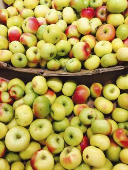 Green and red apples in a stall, market.