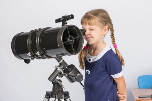 Girl amateur astronomer watching the stars through a telescope