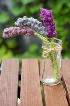 Beautiful knitted lavender flower for home decoration, homemade product knit from yarn, set on table in garden