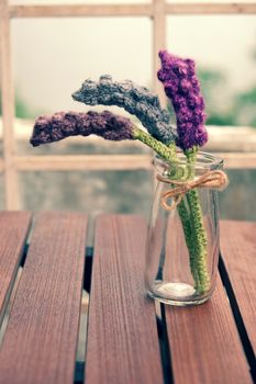 Beautiful knitted lavender flower for home decoration, homemade product knit from yarn, set on table in garden