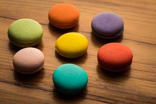 Image of a ring of colorful macaroons on wood
