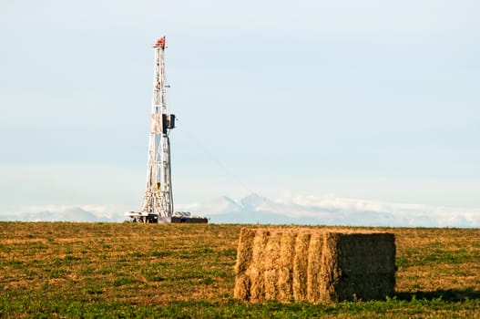 Drilling rig set up in an alfalfa field east of the Rocky Mountains in central Colorado, USA.