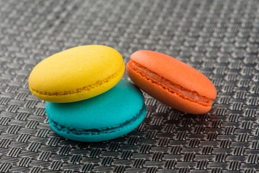 colorful macaroons on a gray metallic surface