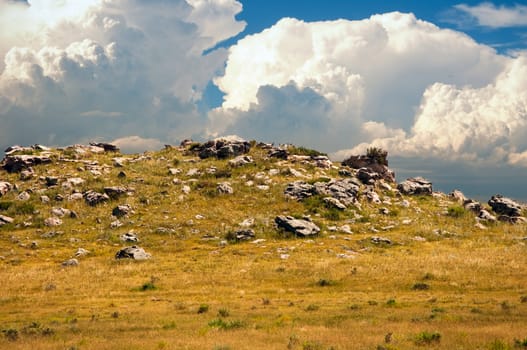 Storm clouds gathering over a rocky outcrop on section of Wyoming prairie