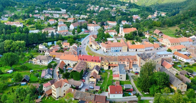 View of the Vranov nad Dyji village from the top of the hill. View of the village centre with many small houses, parked cars, river Thaya and major street.